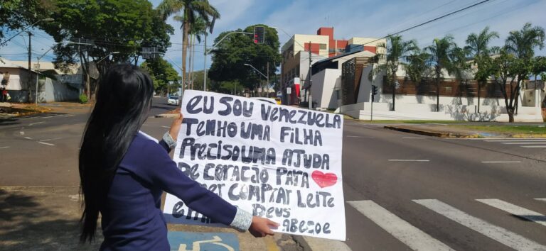 Com cartazes, venezuelanos pedem ajuda nos semáforos de Umuarama