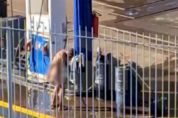 Cena inusitada: homem é pego tomando banho com mangueira em posto de gasolina
