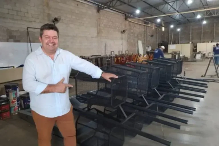 empresário branco em pé sorrindo e mostrando como é possível produzir com lixo um produto