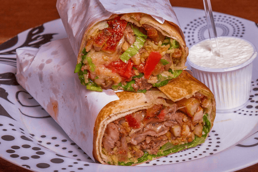 imagem de uma Chawarma cortada ao meio com um pote de maionese do lado