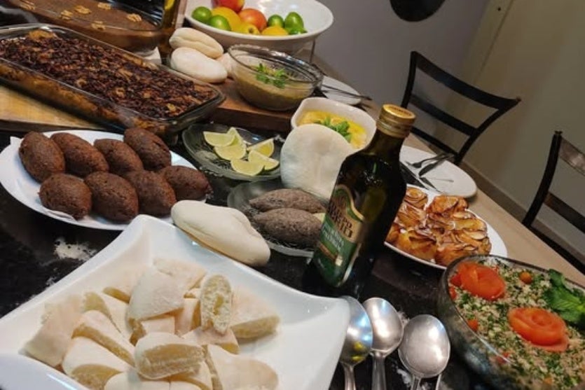 Imagem de uma mesa com vários pratos de comida árabe.