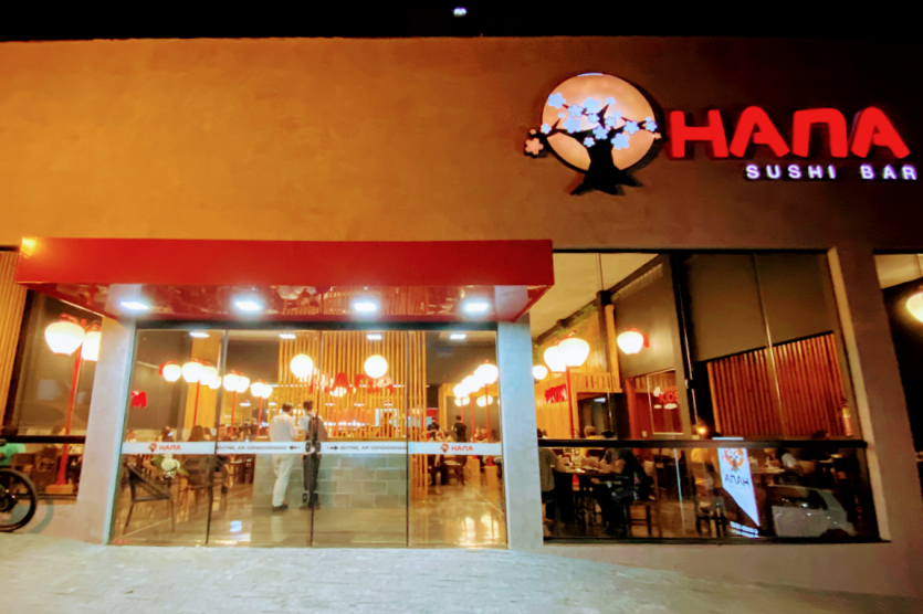 Fachada do Hana Sushi Bar, que serve Comida oriental em Umuarama, a noite com as luzes acesas. 