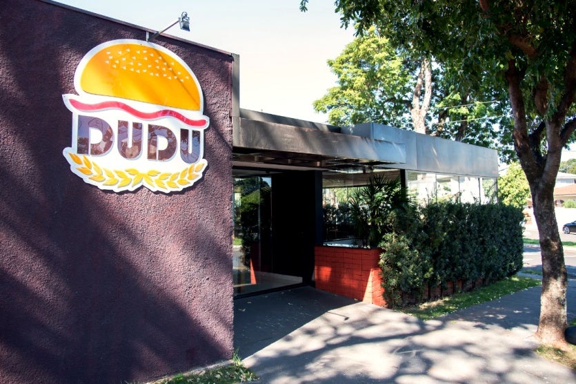 Foto da fachada da empresa. O dia está ensolarado.