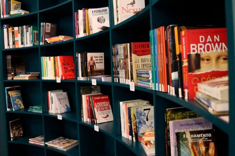 Prateleiras com livros de diversos segmentos no Sicoob Arenito.