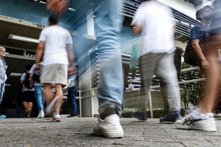 Concurso público: Na foto, pessoas caminhando no local de prova.