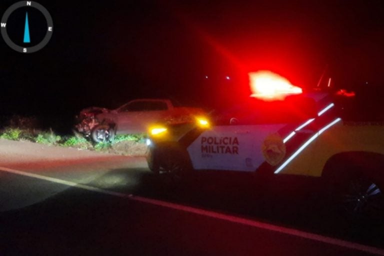 A colisão traseira na PR-323. Na foto, a caminhonete Ram com a frente destruída, ao lado de uma viatura da PRE.