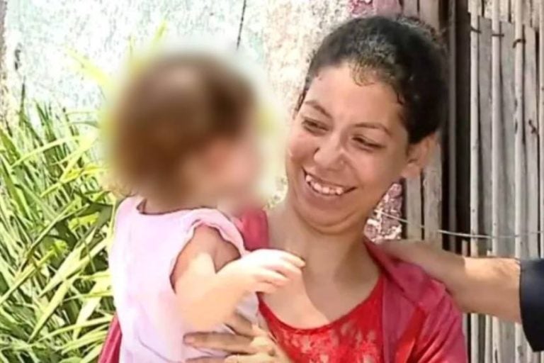Na foto, a mãe de Eloah segurando a filha nos braços durante entrevista.