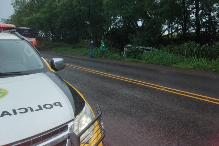 Capotamento na PRC-487. Na foto, uma viatura da Polícia Rodoviária Estadual e o veículo envolvido no acidente caído em uma ribanceira.