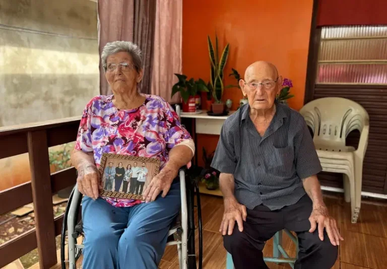 Casal de idosos de 99 anos sentados um do lado do outro e compartilhando em uma entrevista os segredos de uma vida a dois