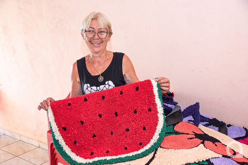 Dona de casa de Umuarama segurando um dos seus tapetes.