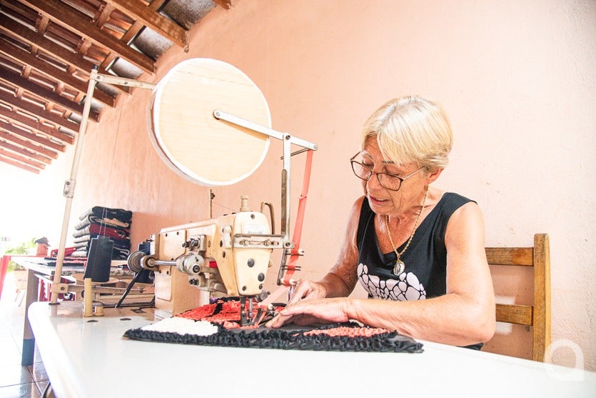 Dona de casa de Umuarama costurando tapete.