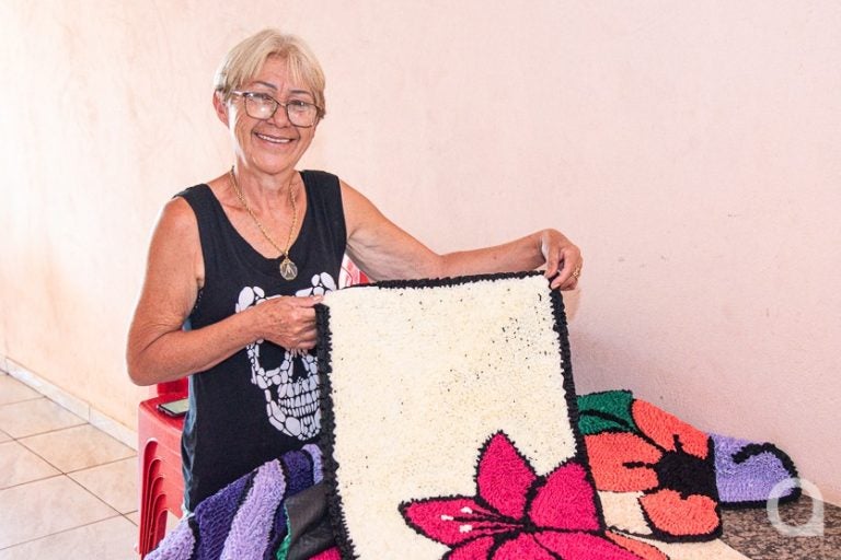 Dona de casa de Umuarama segurando o tapete que ela produziu.
