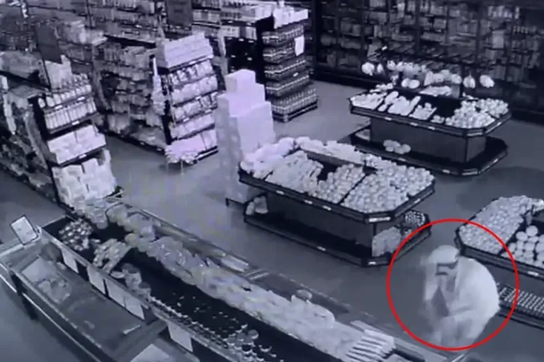 Dentro do supermercado, o criminoso abre um balcão refrigerado e pega alguns itens.