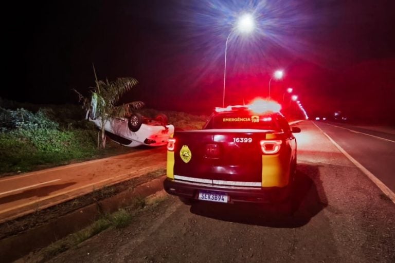Motorista capota veículo na PR-498. Na foto, o veículo da vítima com as quatro rodas para cima ao lado de uma viatura da PRE.