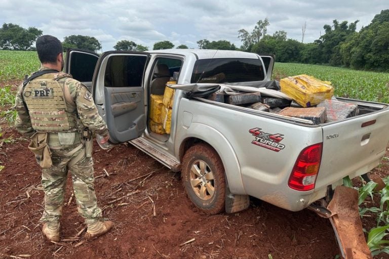 Condutor abandona uma tonelada de maconha em fuga da PRF. Na foto, o veículo apreendido ao lado de um policial.
