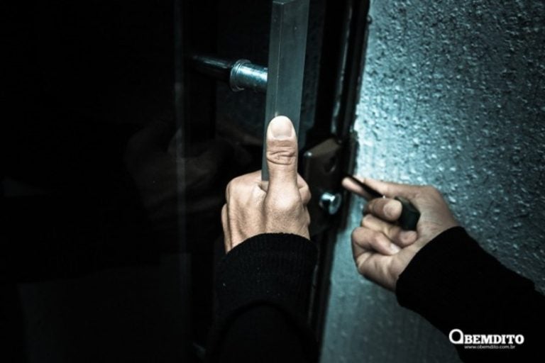 R$ 5 mil em roupas são furtadas em comércio de Umuarama. Na foto, uma mão forçando a entrada em uma porta para ilustrar a matéria.