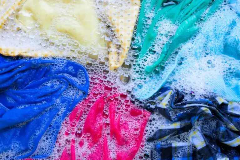 Foto de roupas mergulhadas em água com sabão para ilustrar a matéria sobre lavar roupas coloridas do jeito certo