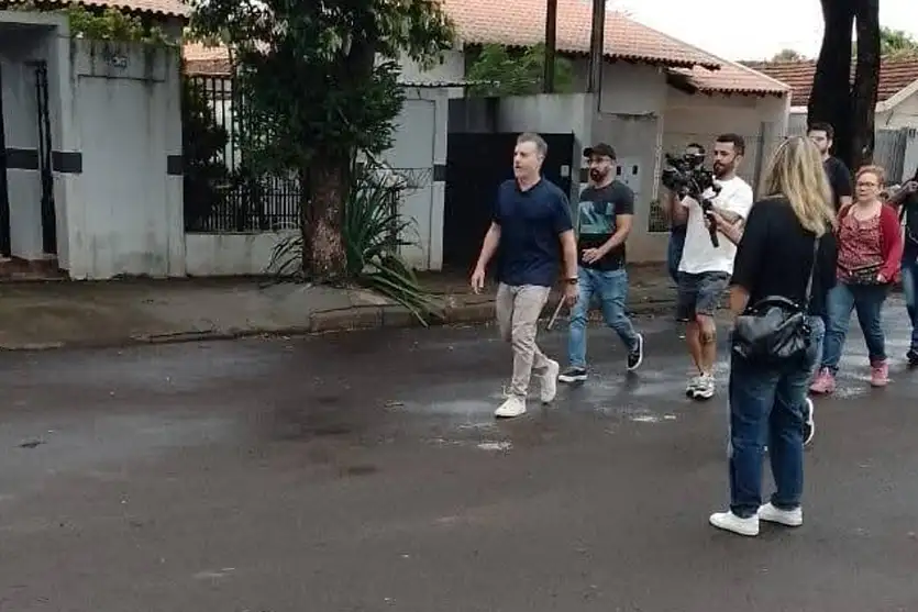 Luciano Huck caminhando pela rua com sua equipe de gravação em Cianorte. 