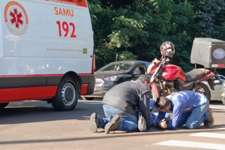 De joelhos, motorista reza ao lado de motociclista ferido após acidente