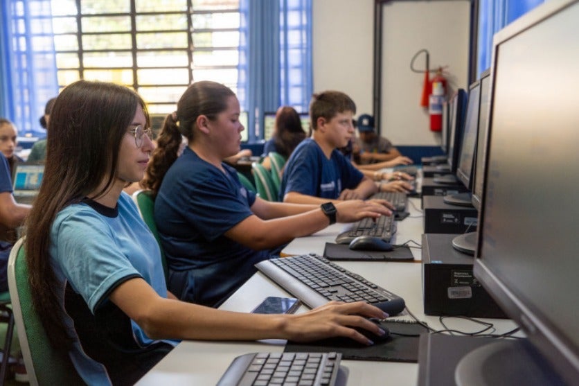 Alunos utilizando computadores em sala de aula.