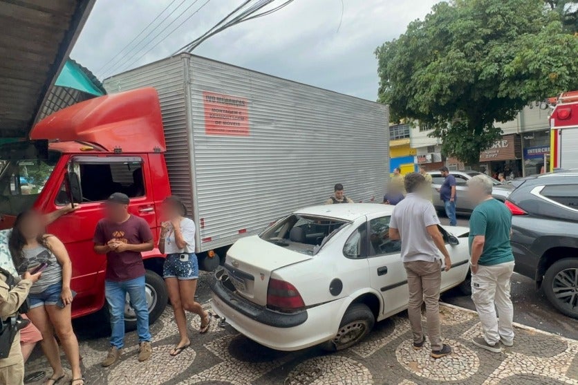 Na foto, pessoas ao redor do caminhão desgovernado que atingiu carros estacionados no Centro de Umuarama.