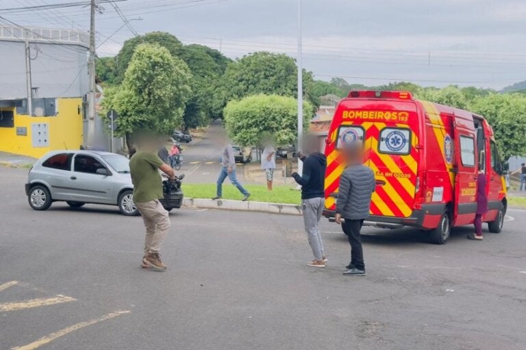 Foto de uma ambulância e pessoas no local do acidente envolvendo uma adolescente atingida por um automóvel nas proximidades do Colégio José Balan, em Umuarama.