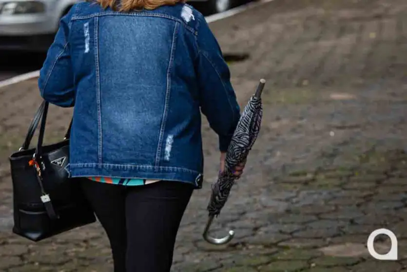 Foto de uma mulher carregando um guarda-chuva em Umuarama.