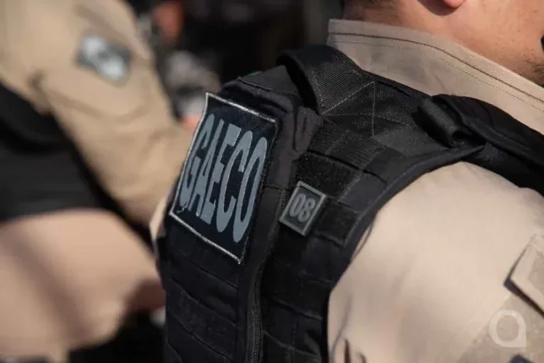 Foto de um policial com um colete do Gaeco.