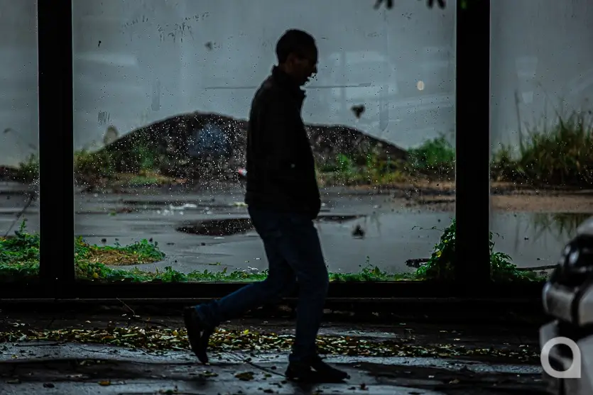 Foto de sábado frio em Umuarama, com pedestre caminhando em ambiente chuvoso.