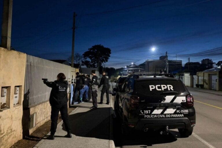 Policiais ao lado de uma viatura da PCPR.