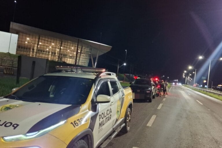 Foto de uma viatura da PRE ao lado de um dos veículos envolvidos em acidente na PR-323 em Umuarama.