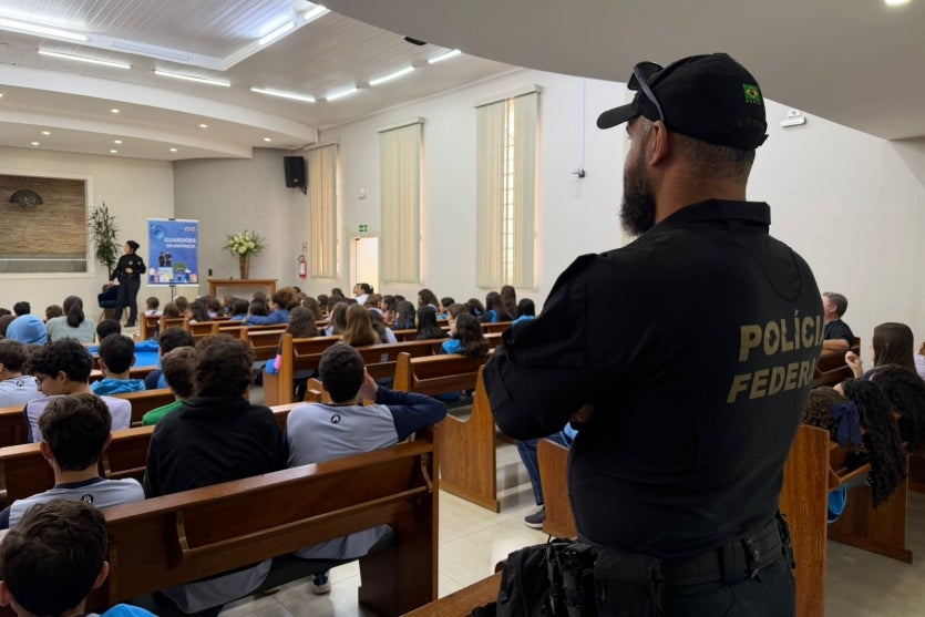 Policial federal durante a apresentação do projeto Guardiões da Infância, em Guaíra. Local está com crianças assistindo a palestra.