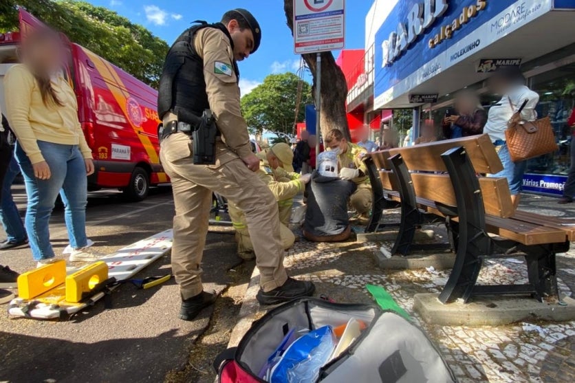 Vítima de acidente na avenida Paraná sendo socorrida. Pessoas se aglomeram ao redor.