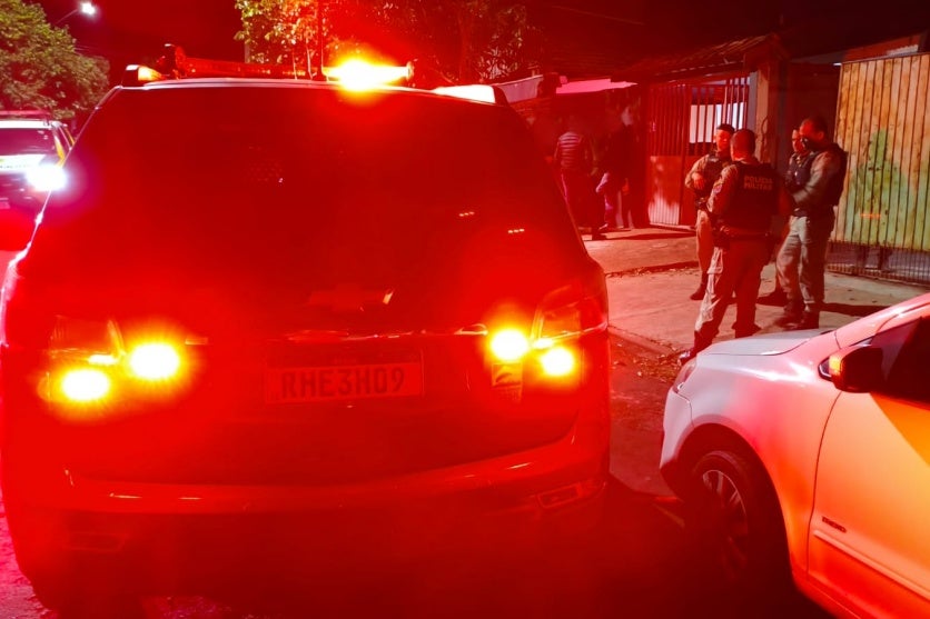 Local da tentativa de homicídio em Umuarama. Viatura da PM, policiais e testemunhas também estão na foto.