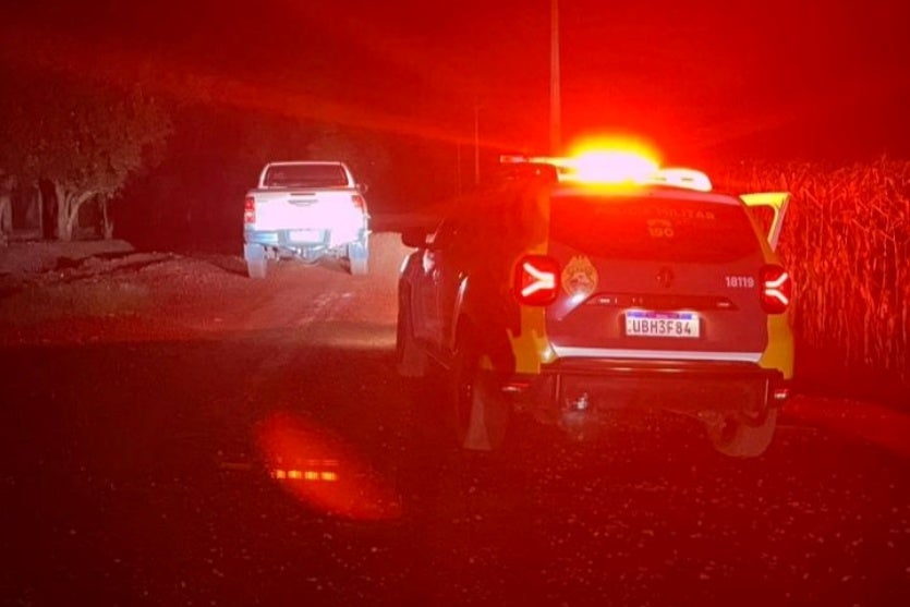 Hilux furtada e recuperada. Veículo está ao lado de uma viatura da PM.