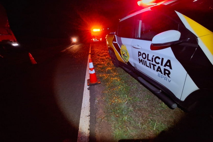 Foto do local do acidente na PR-218, em Querência do Norte, próximo a uma viatura da PRE.