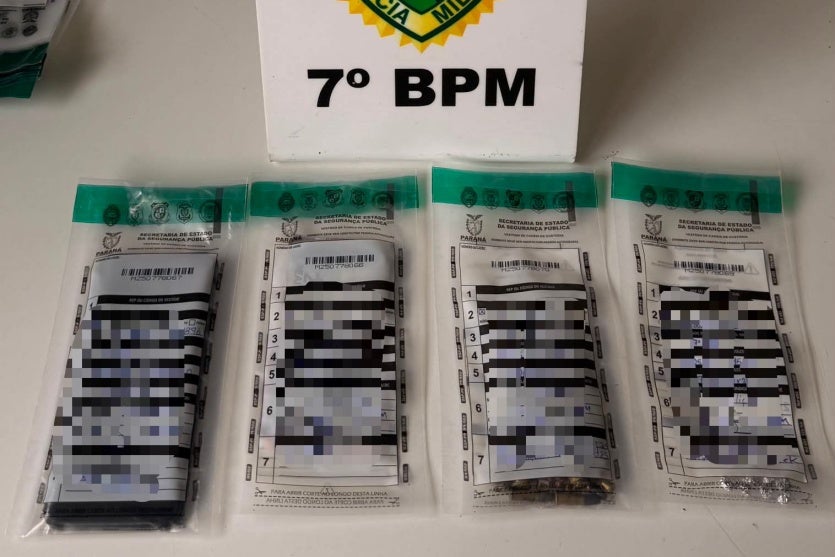 Drogas e munições dentro de envelopes dispostos na mesa da PM.