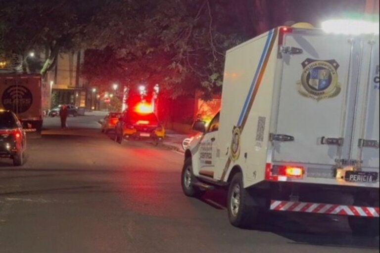 Viatura do IML ao lado do local de um homicídio em Maringá.