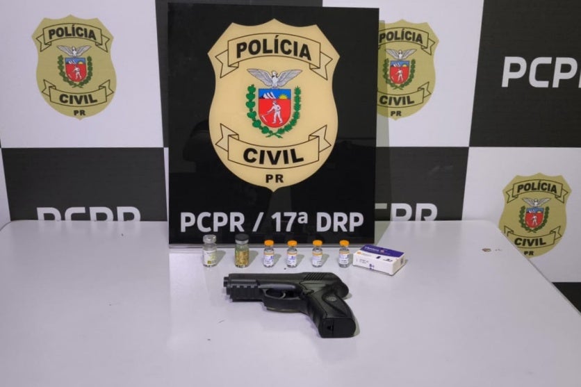 Arma e medicamentos emagrecedores dispostos em uma mesa da PCPR em Cruzeiro do Oeste.