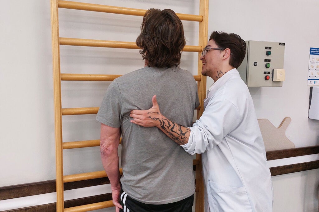 Médico tratando paciente com dificuldade motora.