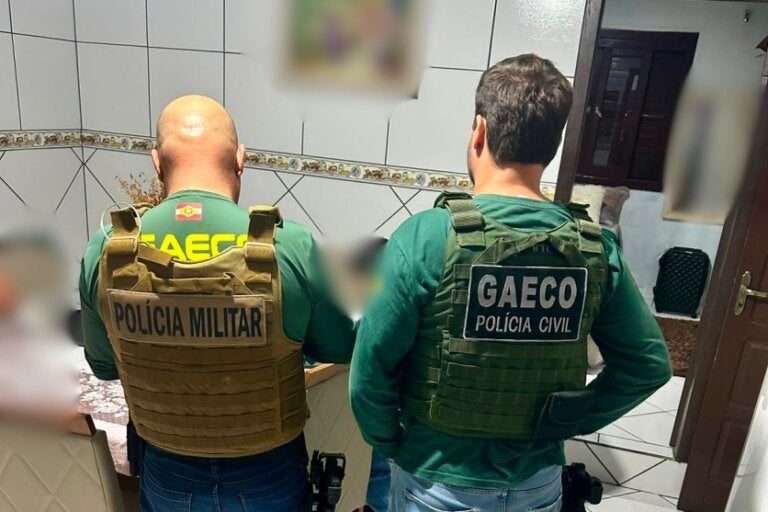 Agente do Gaeco e policial militar durante cumprimento da Operação Gabarito em Branco em Umuarama.