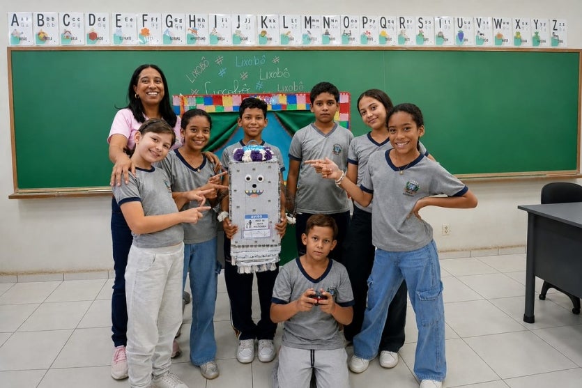 Alunos de Umuarama ao lado de robô reciclador.