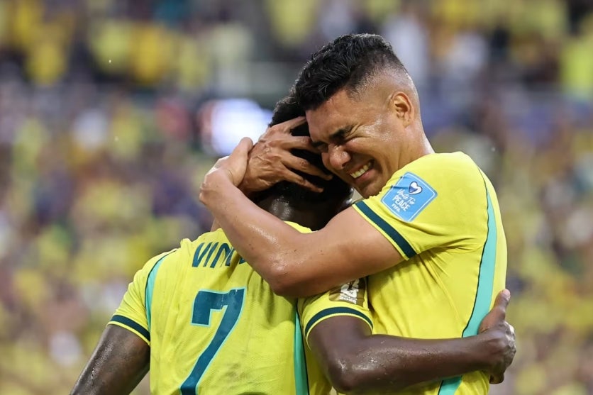 O volante Casemiro e o atacante Vini Jr. se abraçando durante vitória sobre a Escócia.