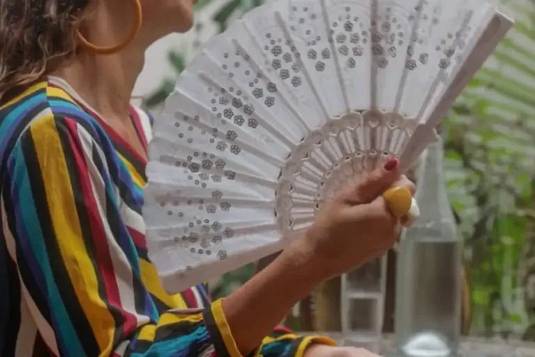 Mulher se abanando com um leque.