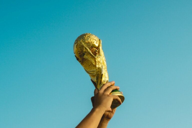 Jogador de futebol levanta o troféu da Copa do Mundo com as duas mãos
