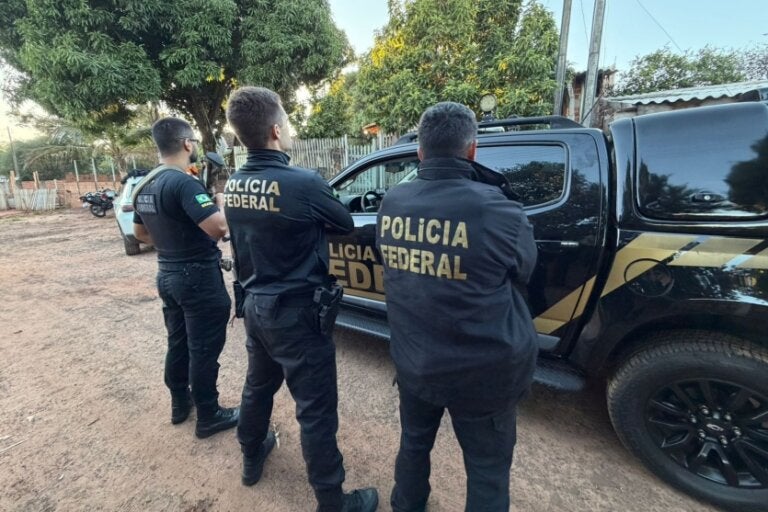 Policiais federais de frente para uma viatura durante a Operação Guardiões do Amanhã V.