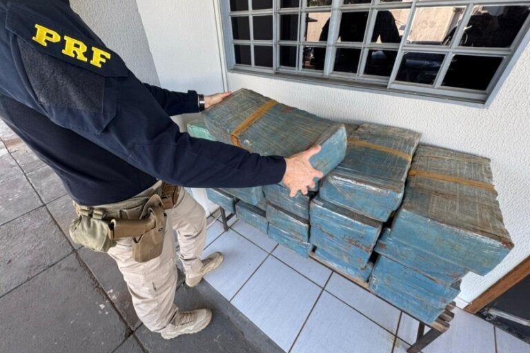 Policial federal ao lado de mais de 400 kg de maconha na PR-323 em Perobal.