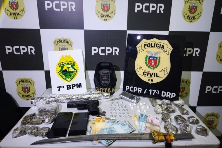Materiais apreendidos durante a Operação Efeito Dominó. Há drogas, armas de fogo e branca, além de dinheiro e outros objetos.