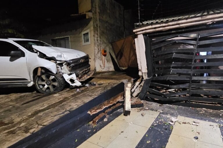 Foto de veículo que colidiu contra residência em Pérola. S10 e portão da casa estão destruídos.