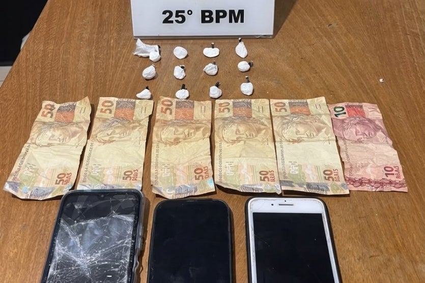 Celulares, drogas e dinheiros apreendidos e dispostos em uma mesa da PM de Umuarama.